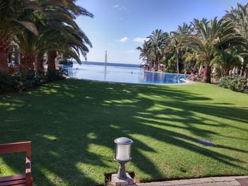 View of golf course by sea against sky