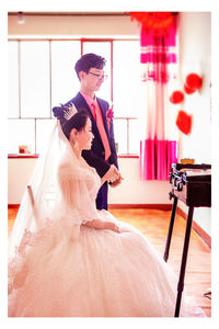 Young couple standing against wall