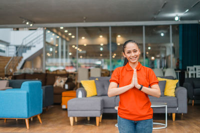 Portrait of young woman using mobile phone while sitting in cafe