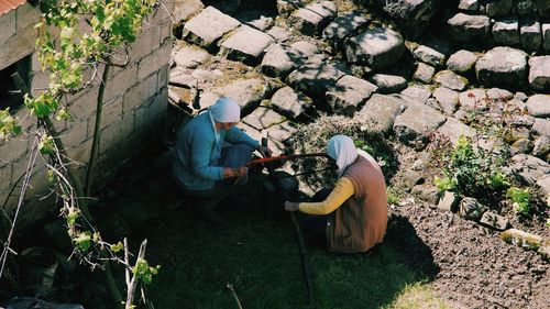 Two old women chopping wood