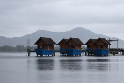 Houses by lake against sky