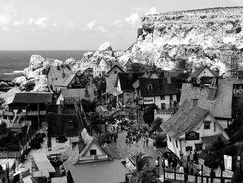 High angle view of townscape by sea against sky