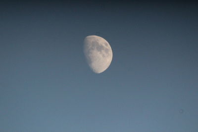 Low angle view of moon against clear blue sky