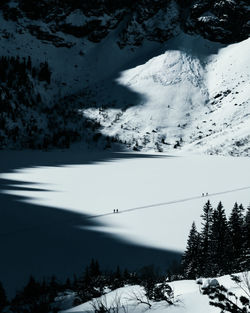 Scenic view of snowcapped mountains against sky during sunset and people walk on a frozen lake