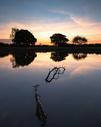 Scenic view of lake against sky during sunset