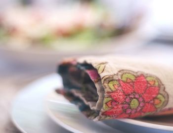 Close-up of patterned napkin in plate on table