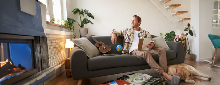 Portrait of woman using digital tablet while sitting on sofa at home
