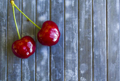 Top view of pair of cherries on rustic background