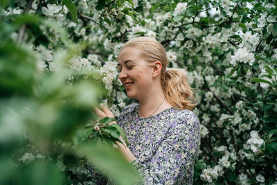 Girl with blond hair in blossoming apple tree outdoor nature