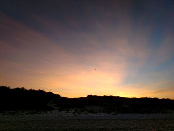 Scenic view of silhouette trees against sky at sunset