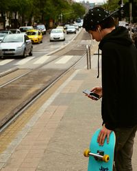 Man using mobile phone on road in city