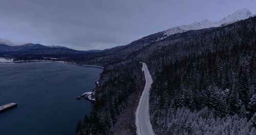 Scenic view of river by mountains against sky