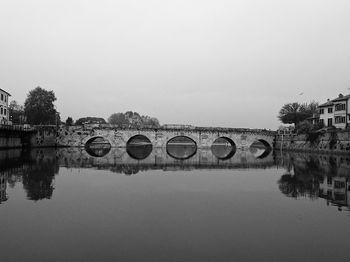 Arch bridge over river against sky