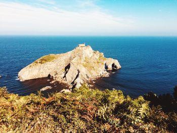 Scenic view of rocks in sea against sky