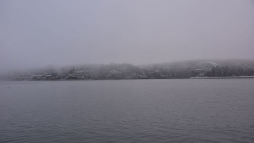 Scenic view of lake against sky during foggy weather