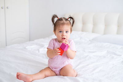 Portrait of cute baby boy lying on bed at home