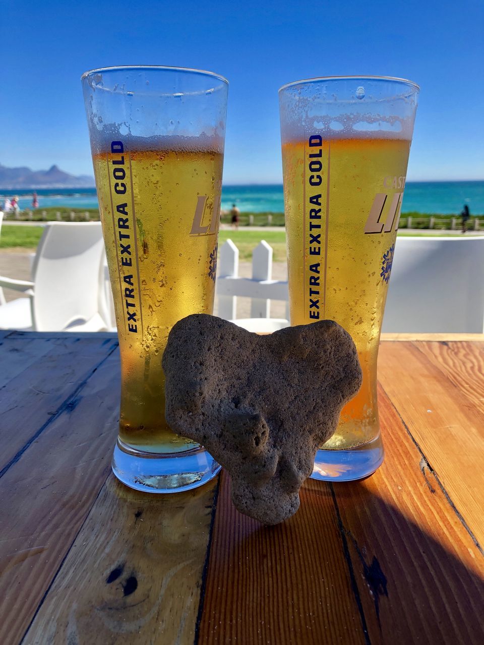 CLOSE-UP OF BEER ON TABLE AGAINST BLURRED BACKGROUND