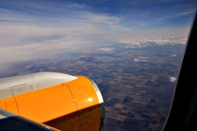 Cropped image of airplane wing over landscape