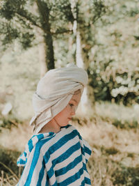 Side view of thoughtful girl standing on field 