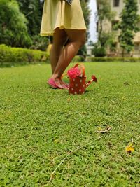 Low section of woman standing on field