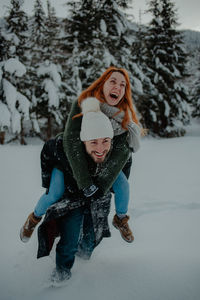 Full length of smiling woman in snow