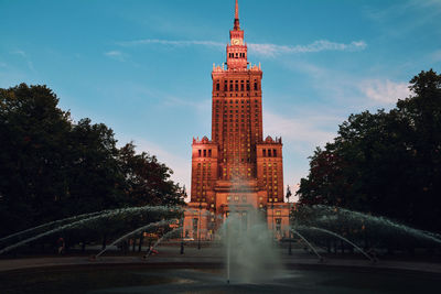 Tower of building against cloudy sky