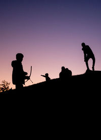 Silhouette people standing against clear sky during sunset