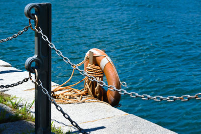 Rope tied to wooden post in sea