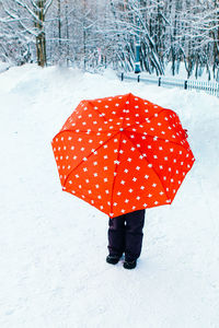 Woman standing on snow covered field