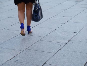 Low section of woman standing on tiled floor