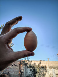 Low angle view of person hand against clear sky