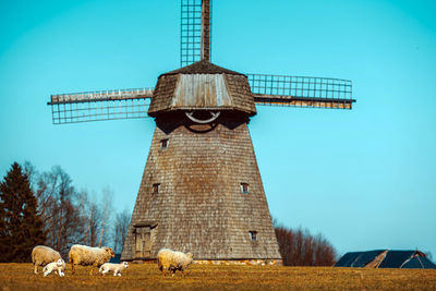 Traditional windmill on field against sky