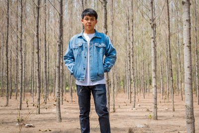 Portrait of teenage boy standing in forest