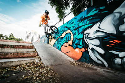 Low angle view of graffiti on wall against sky