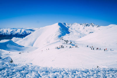 Scenic view of snowcapped mountains against blue sky