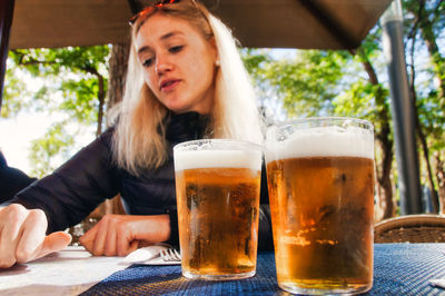 Young woman sitting by beer glasses