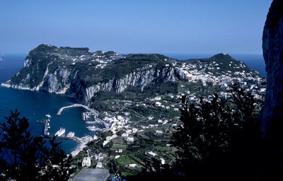 Scenic view of sea and mountains against clear sky