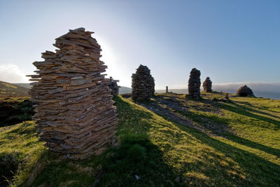 Rocks on field against clear sky