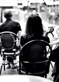 Rear view of woman sitting on bench