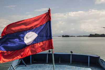 Red flag on pole against blue sky