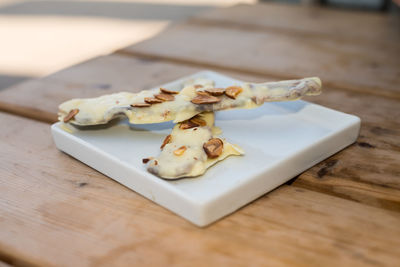 Close-up of white chocolate covered bacons in plate on table