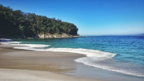 View of calm beach against blue sky