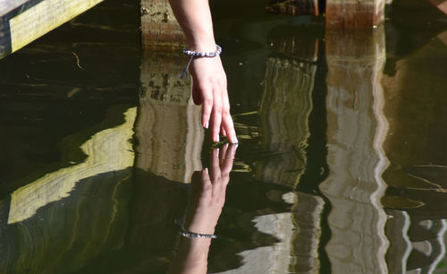 Low section of woman standing by lake