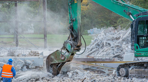 Excavator by demolished built structure