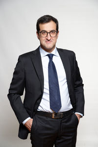 Portrait of mid adult man standing against white background