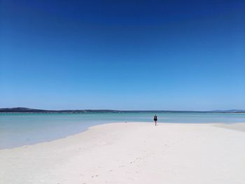 Scenic view of beach against clear blue sky