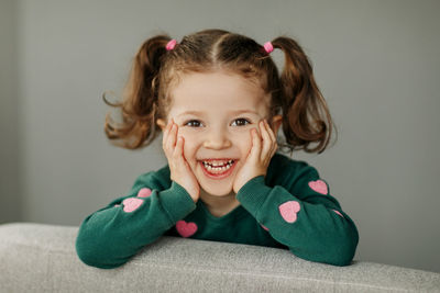 Portrait of a charming little girl with two ponytails, joyful and smiling