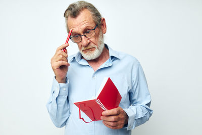 Young man holding key against white background