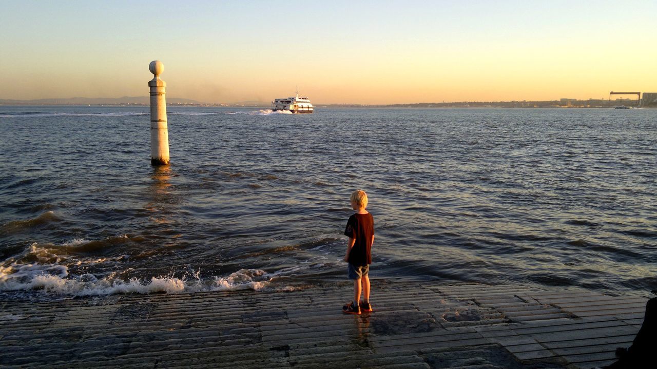 water, sea, sunset, transportation, nautical vessel, mode of transport, boat, horizon over water, rippled, orange color, tranquility, sky, tranquil scene, scenics, nature, pier, clear sky, one person, beauty in nature, travel