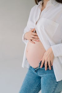 Midsection of woman standing against white background